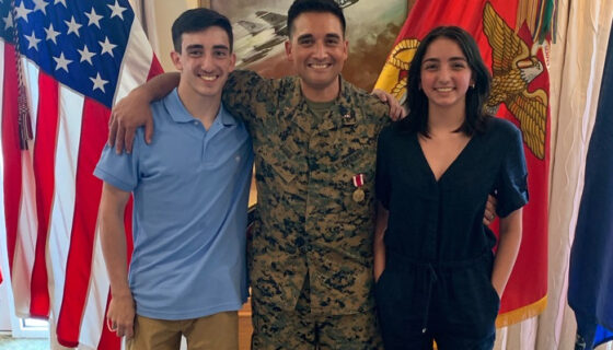 Marine standing front of flags