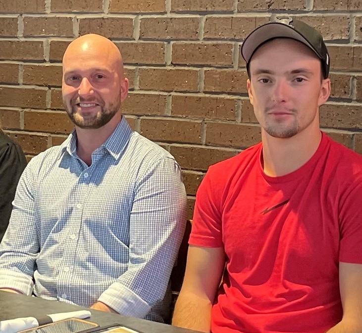 Two brothers sit together at a networking event