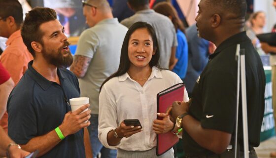 Man and woman smiling and looking to the right in conversation with a potential employer