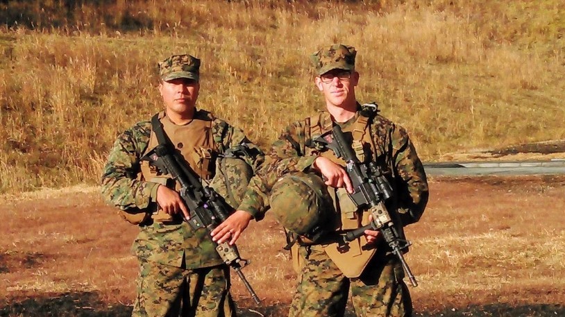 Marines stand with gear and weapons