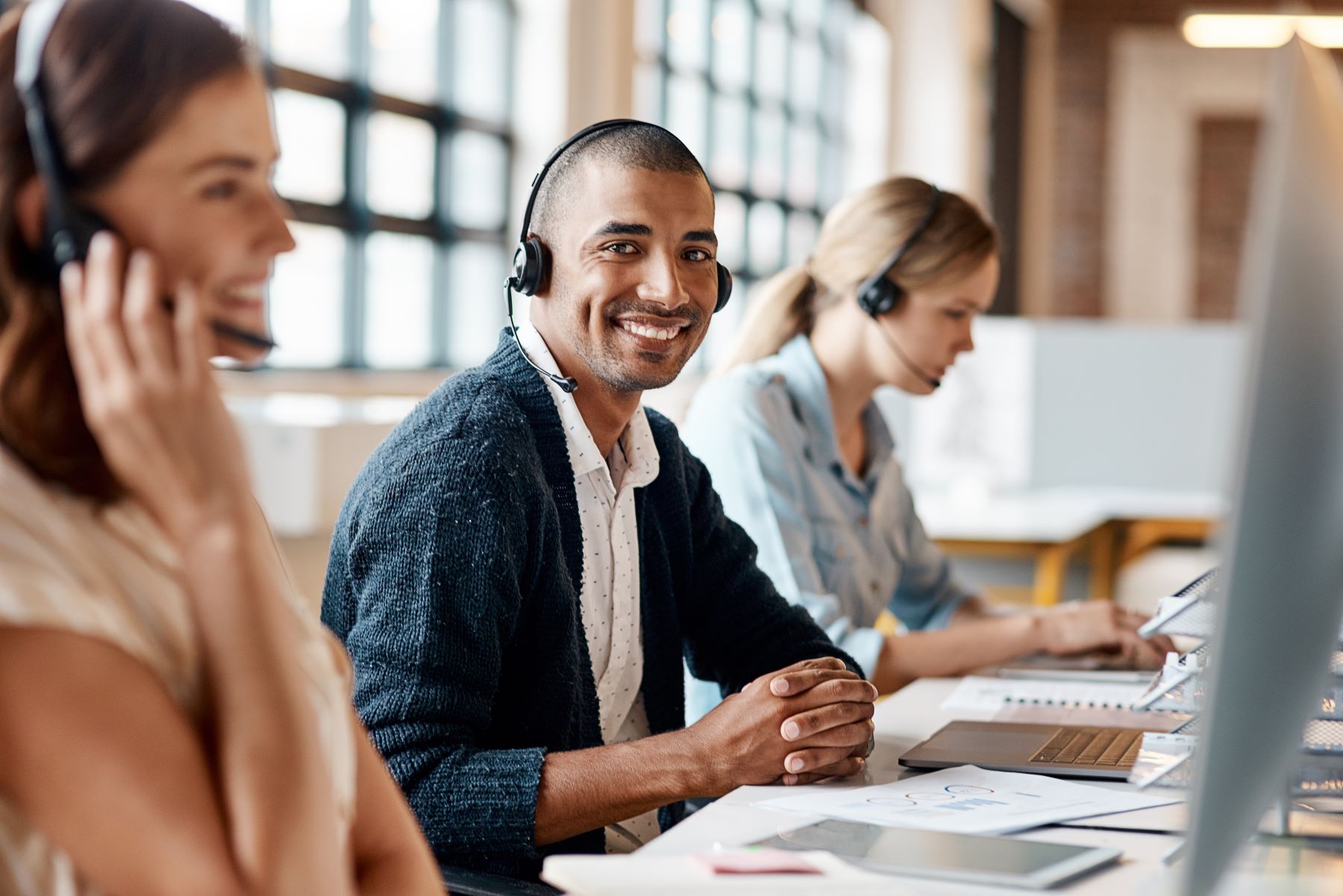 man working at laptop smiles at camera