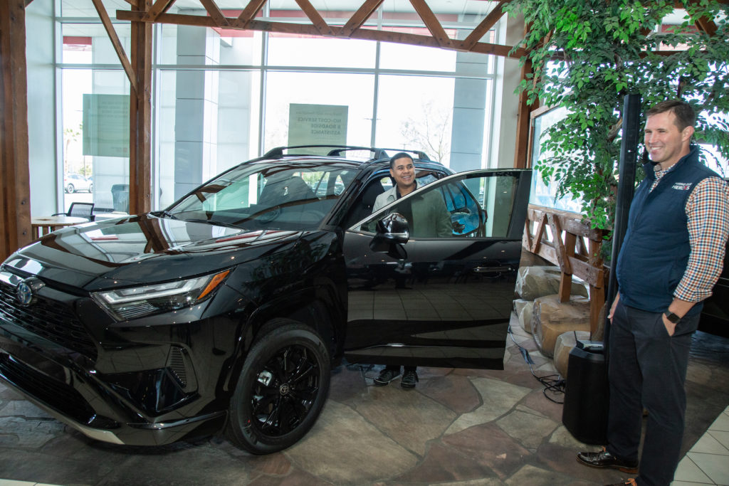 Air Force veteran Adlai Ceja climbs into his new Toyota RAV4 hybrid