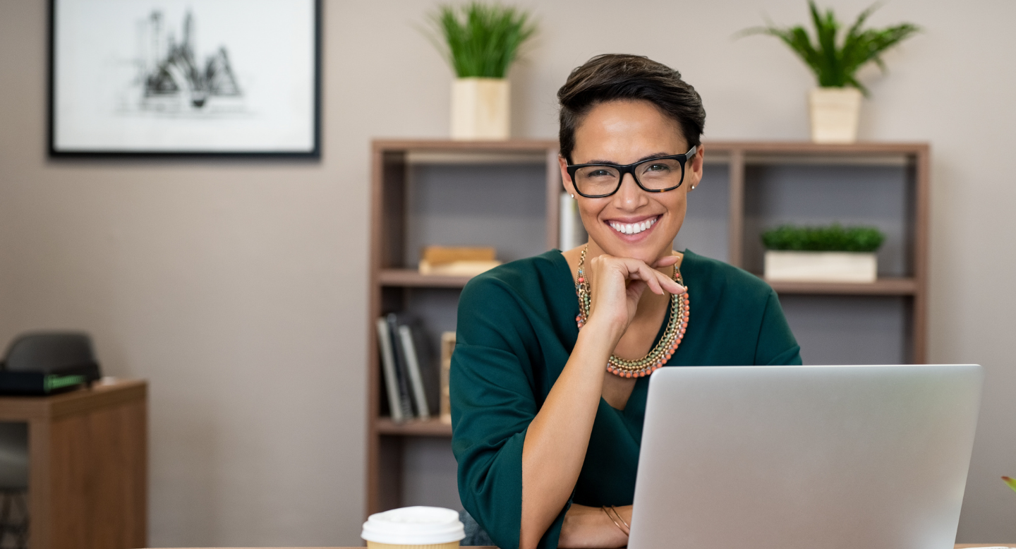 smiling woman sitting at a computer